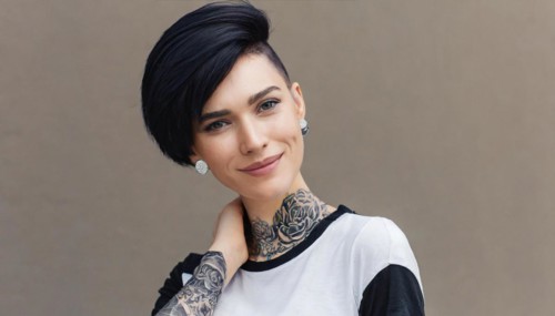 A smiling woman with a modern short hairstyle and eye-catching tattoos in stylish black and white