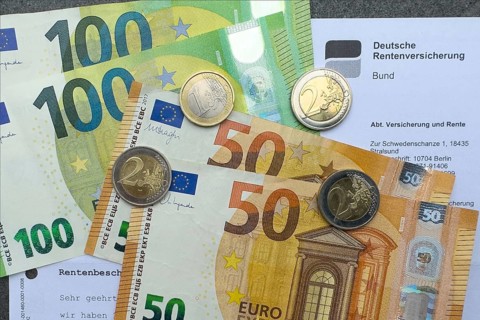 Symbol photo document pension certificate from Deutsche Rentenversicherung on cash banknotes euro