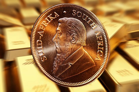 Close-up of a Krugerrand gold coin, in the background blurred gold bars (composing)
