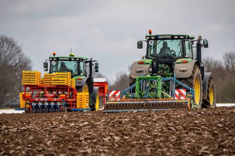 Tractor with a power harrow prepares the soil of a field for planting, Agriculture, Spring