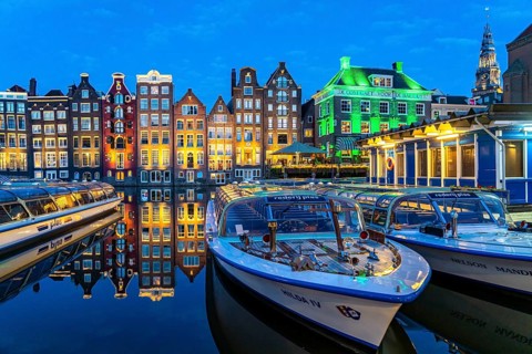 Canal houses on the Damrak, in the centre of the old town of Amsterdam, harbour, starting point of