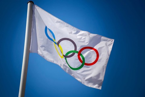 Olympic flag in front of a blue sky