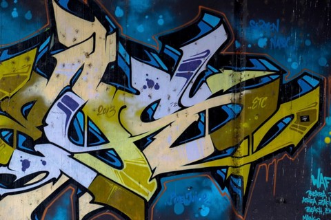 Graffiti artwork in blue and yellow with the year 2016 visible on an urban wall,