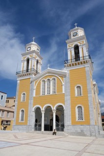 Modern church with yellow façade and two towers on a public square, Cathedral, Ypapantis Sotiros,
