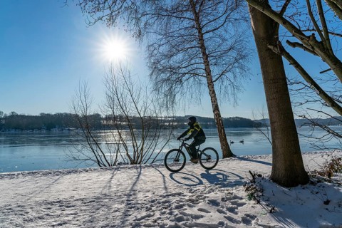 Winter in the Ruhr area, Lake Baldeney, snow-covered, partly frozen lake, walkers on the lakeside