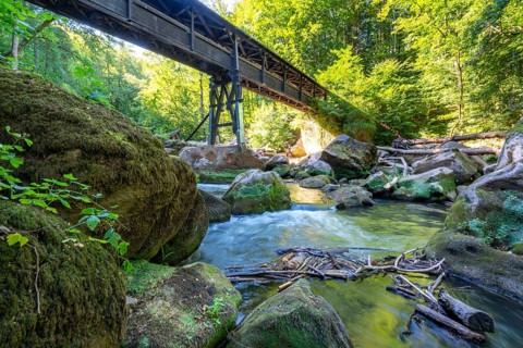 The Irrel Waterfalls, rapids in the lower reaches of the Prüm, covered wooden bridge for hikers,