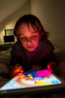 A boy plays computer games on a tablet PC