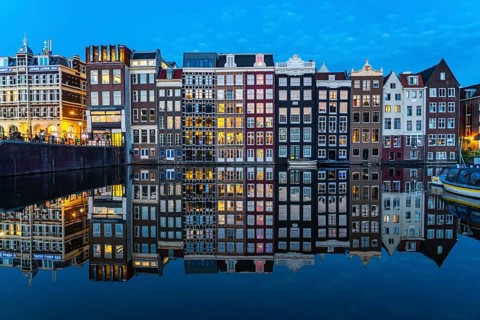 Canal houses on the Damrak, in the centre of the old town of Amsterdam, harbour, starting point of