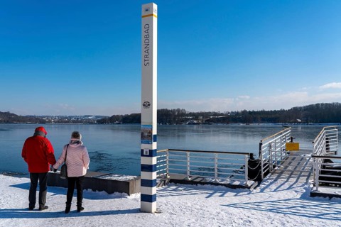 Winter in the Ruhr area, Lake Baldeney, snow-covered, partly frozen lake, shore, pier Strandbad,