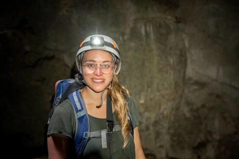 Young woman with helmet and headlamp in a stalactite cave, Terciopelo Cave, Barra Honda National