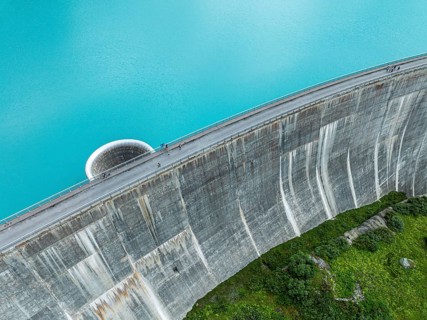 Dam of the Moiry lake, Lac de Moiry, turquoise glacial water, water overflow, tourists, aerial