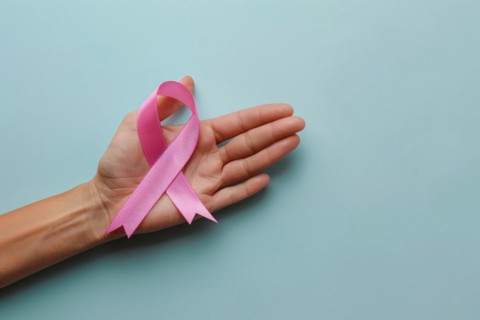 Woman's hand holding pink breast cancer awareness ribbon. KI generiert, generiert, AI generated
