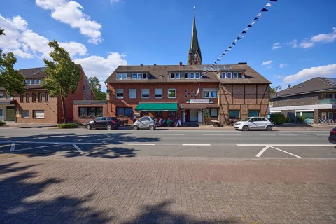 Weseler Strasse with buildings and St. Pankratius church in the Buldern district, Dülmen,