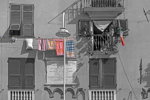 Residential building façade with green shutters and hanging laundry in the historic city centre,
