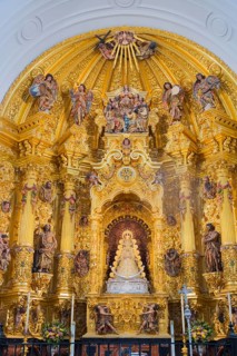 Üppiger barocker Altar mit goldenen Verzierungen und religiösen Statuen in einer Kirche, heilige