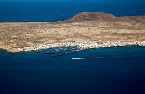 Ferry ship approaching Caleta del Sebo, La Graciosa island, Lanzarote, Canary Islands, Spain view