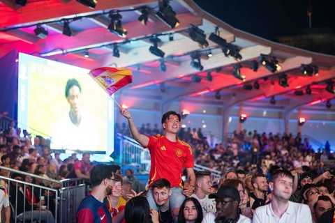 Fan of the Spanish team waving a flag at the Adidas fan zone at the Bundestag during the final