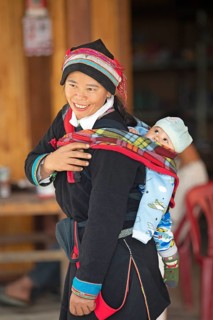 Vietnamese woman, 43 years old, in traditional traditional costume of the Dao minority, carrying