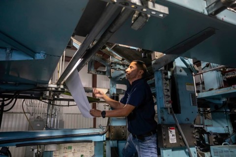 Liberal, Kansas, Danny Moura sets up the printing press at the Leader & Times. Besides its own