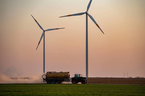 Tractor tilling a field in spring, spreading fermentation residue, residual slurry from biogas