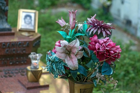 Faded plastic flowers on a grave in the Staglieno Monumental Cemetery, Cimitero Monumentale di