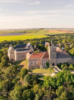 Aerial view of a wide medieval castle, embedded in green landscape and open terrain, Allstedt,