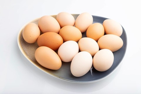 Pile of colored chicken eggs on plate isolated on white background. side view, close up