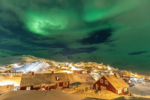 Northern Lights, Aurora borealis over houses, Inuit settlement, Winter, Tasiilaq, East Greenland,