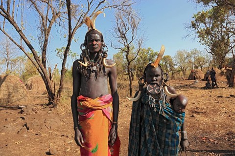 Southern Ethiopia, in Maco National Park, Mursi tribe, Mursi man, Mursi woman with baby, painted