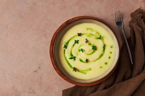 Mashed potatoes, with green butter and micro greenery, homemade, on a beige table, no people, top
