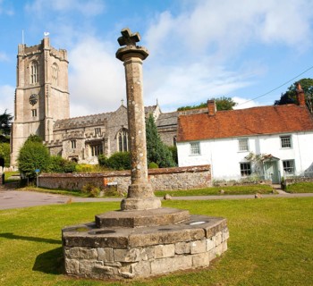 Church of St Michael and butter cross on the village green in Aldbourne, Wiltshire, England, United