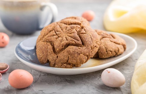 Homemade oatmeal cookies with a cup of cocoa and a yellow textile on a gray concrete background.