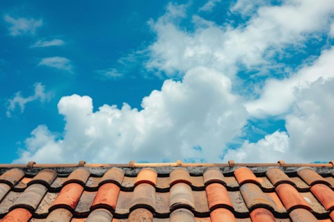 Close up of roof with red ceramic tiles and blue sky. KI generiert, generiert, AI generated