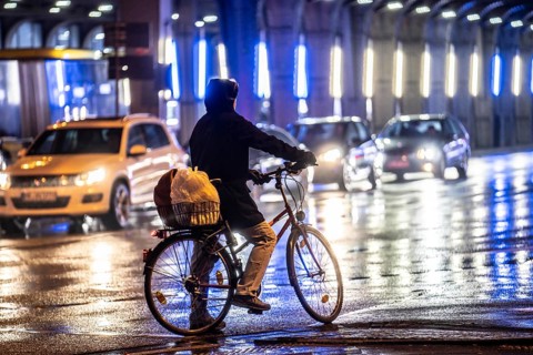 Street at the central station, cyclist, rainy weather, city centre, in the evening, Essen, North