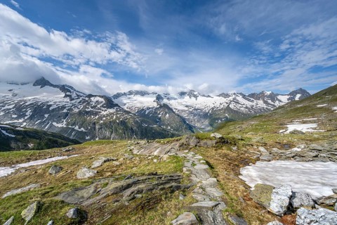 Hiking trail in a picturesque mountain landscape, mountain peaks with snow and glacier