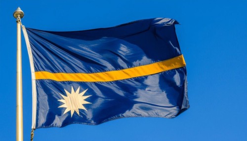 The flag of Nauru, an island nation in the Pacific Ocean, flutters in the wind, isolated against a