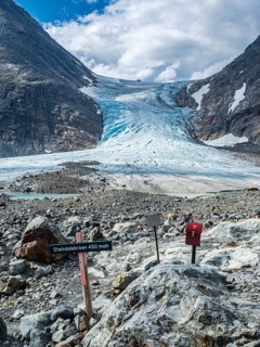 Glacier Steindalsbreen, glacier tongue, signpost and 'trimkassa' at end of valley Steindalen,