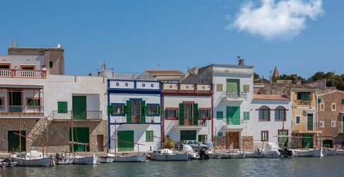 Colourful buildings at the harbour with boats in the foreground and clear sky in the background,