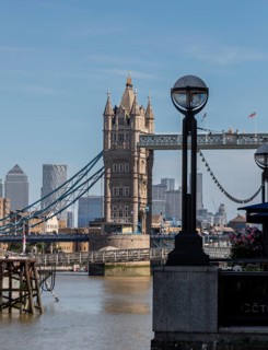 Tower Bridge against a city backdrop and modern skyscrapers, a street lamp in the foreground,