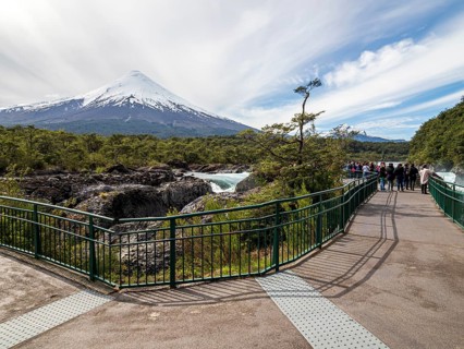 Visitors at the waterfall Saltos de Petrohue, volcano Osorno in the back, chilenean lake district,