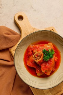 Stuffed cabbage rolls, with minced meat, in tomato sauce, on a beige background, food and drink,