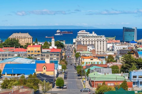 View from a hill over streets and houses to the Strait of Magellan, ships and a tanker in the