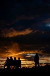 People marvelling at Montafon mountains with dramatic cloudy sky at sunset, Tschagguns, Rätikon,