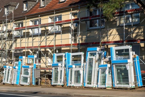Energy-efficient refurbishment of residential buildings, older apartment block is scaffolded, gets
