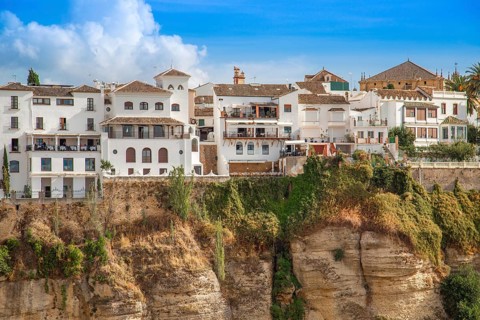 Famous Ronda restaurants and colonial houses overlooking the scenic gorge and the Puente Nuevo