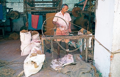 Indian worker winding coils in the Labourers Coir Mats and Mattings Cooperation, coir mat