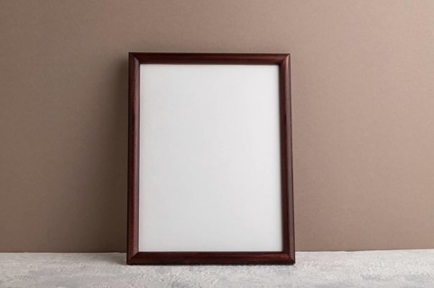Brown wooden frame mockup on beige paper background. Blank, vertical orientation, still life, copy