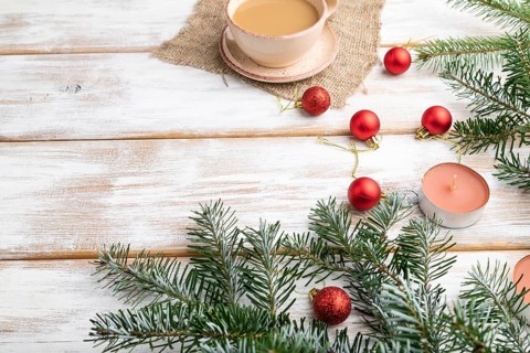 Christmas or New Year composition. Decorations, red balls, fir and spruce branches, cup of coffee,