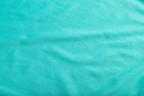 Fragment of smooth silk blue tissue. Top view, flat lay, natural textile background and texture