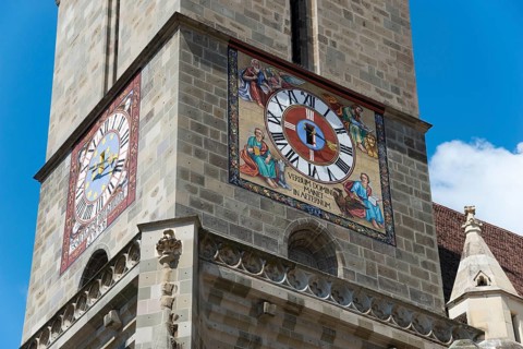 Close-up of a church tower with a large clock and colourful frescoes, Black Church, Old Town,